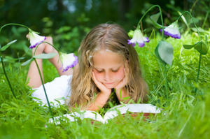 Girl reading outside in the grass