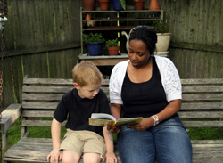 Teacher reading to a child on bench