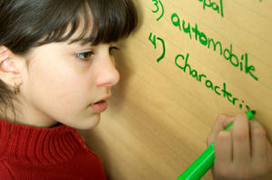 Girl writing spelling words on the flip chart